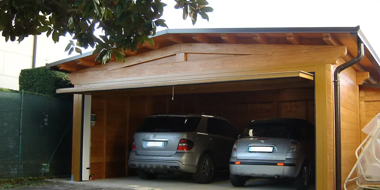 Doppio garage in legno con due auto. La struttura rispetta la normativa garage privati, offrendo un riparo sicuro e funzionale.