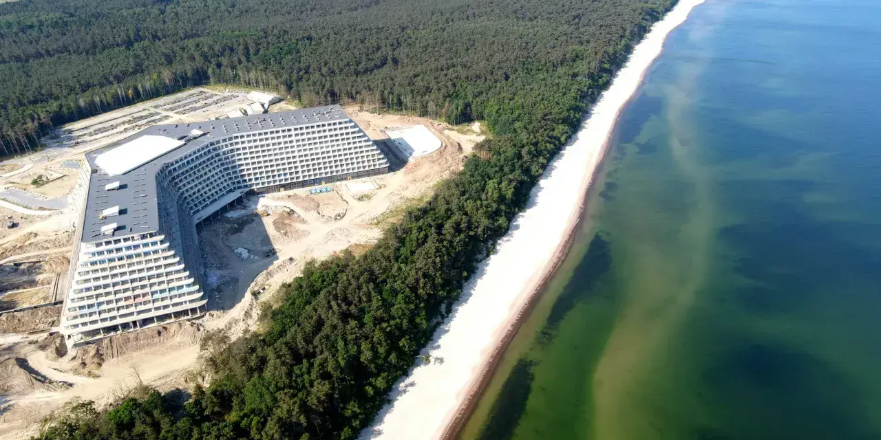 Nowy hotel Gołębiewski w Pobierowie, idealne miejsce na wakacyjny booking. Widok z lotu ptaka na budowę i plażę.