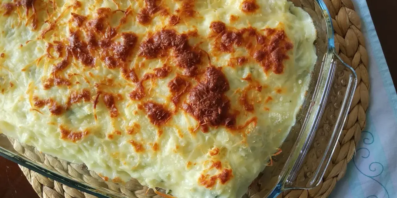 Parmentier de patata gratinado en fuente de cristal, con queso dorado y burbujeante. Un plato reconfortante y delicioso.