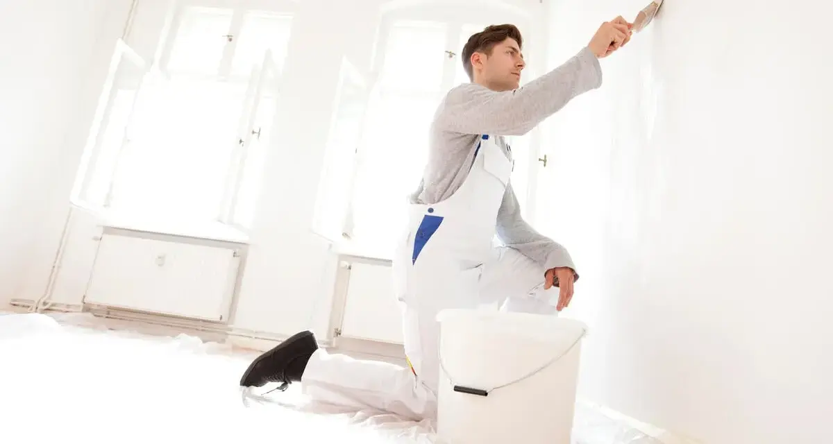 Maler streicht Wand. Kosten für 120 qm Haus streichen? Hier wird renoviert!