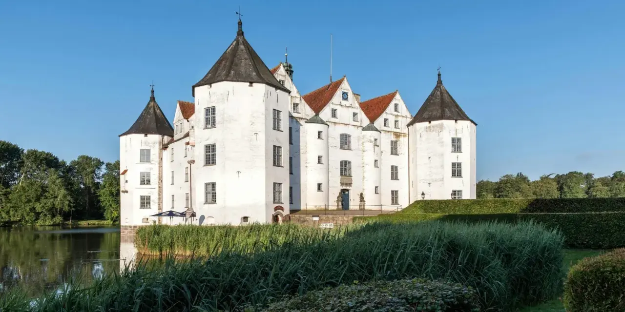 Wasserschloss in Schleswig-Holstein, ideal für die herbstferien 2025. Ein malerisches Schloss mit Türmen und Wassergraben.