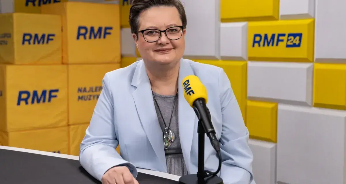 Minister edukacji w jasnej marynarce przed mikrofonem RMF FM.