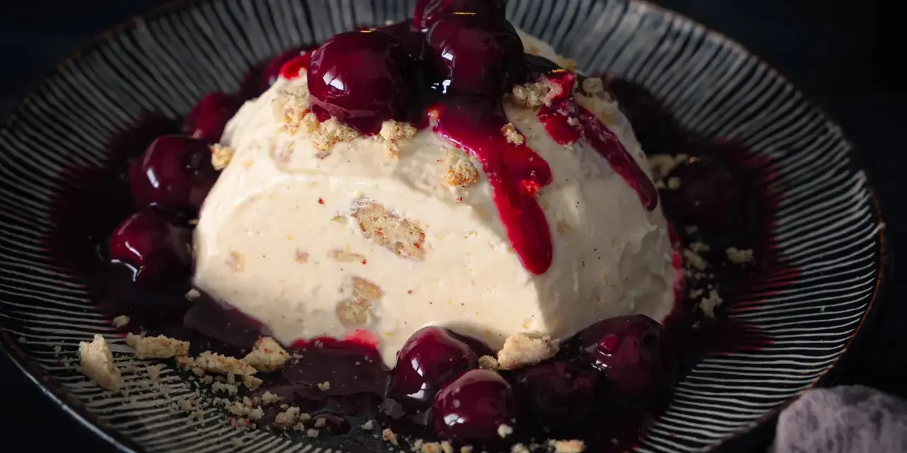 Cremiges Eisparfait mit Kirschsauce und Streuseln, ein köstliches Rezept für heiße Tage.