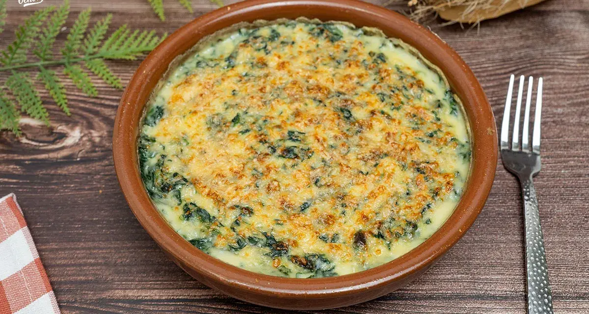 Delicioso plato de espinacas a la crema gratinadas con queso, servido en cazuela de barro. Un bocado cremoso y reconfortante.