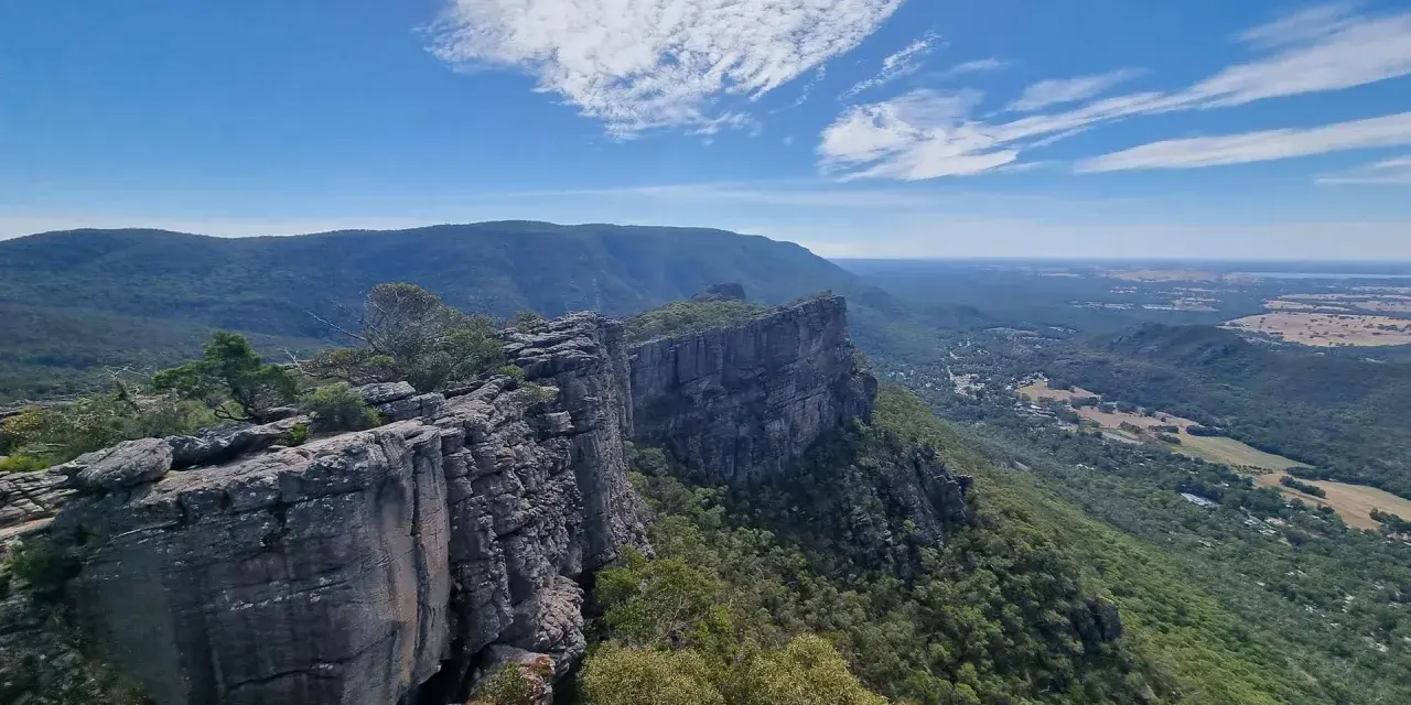 Majestatyczne australijskie góry Grampians z klifami i zielonymi dolinami pod błękitnym niebem.