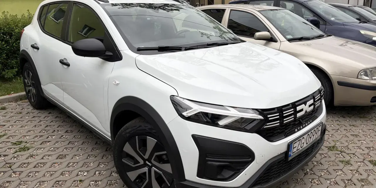 Biały Dacia Sandero Stepway na parkingu. Wiele osób szuka dacia sandero stepway opinie, ten model wygląda obiecująco.