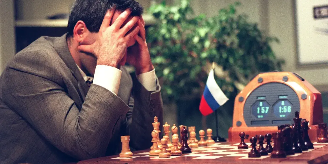 Garry Kasparov, le visage dans les mains, face à Deep Blue. L'horloge d'échecs affiche 1:57 et 1:56.
