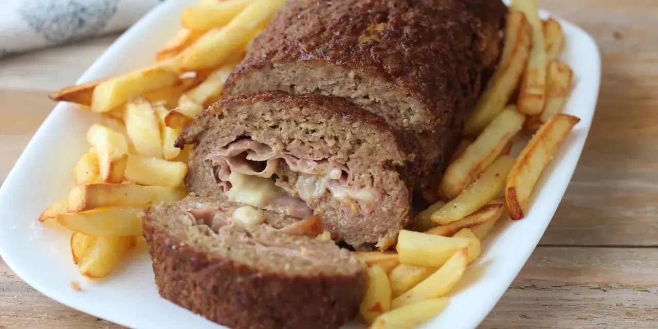 Polpettone ripieno di prosciutto e formaggio, cotto in friggitrice ad aria, servito con patatine fritte croccanti.
