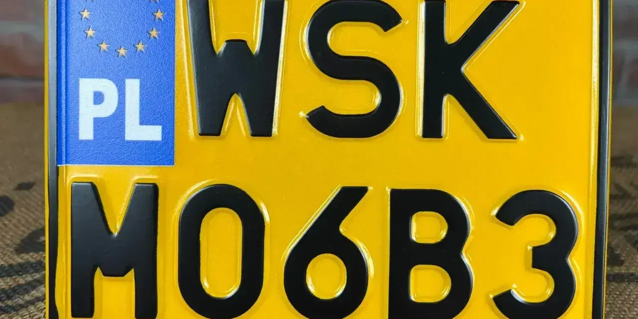 Żółta tablica rejestracyjna z czarnymi znakami "WSK MO6B3" i niebieskim polem "PL" z gwiazdkami UE.