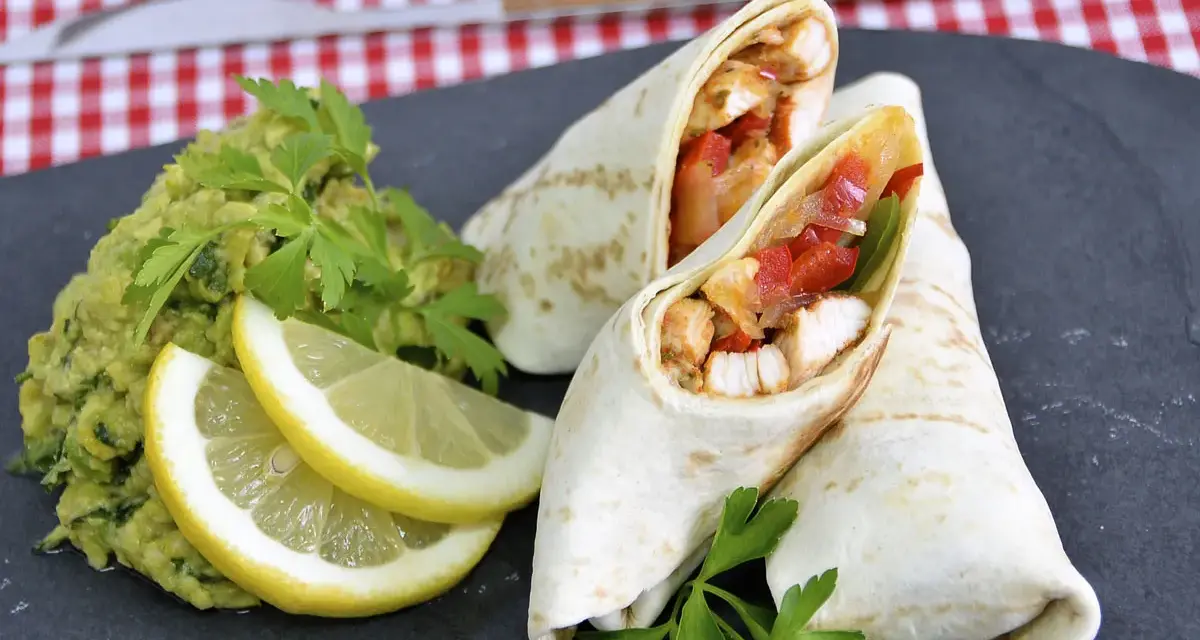 Fajitas de pollo jugosas con guacamole, limón y perejil.