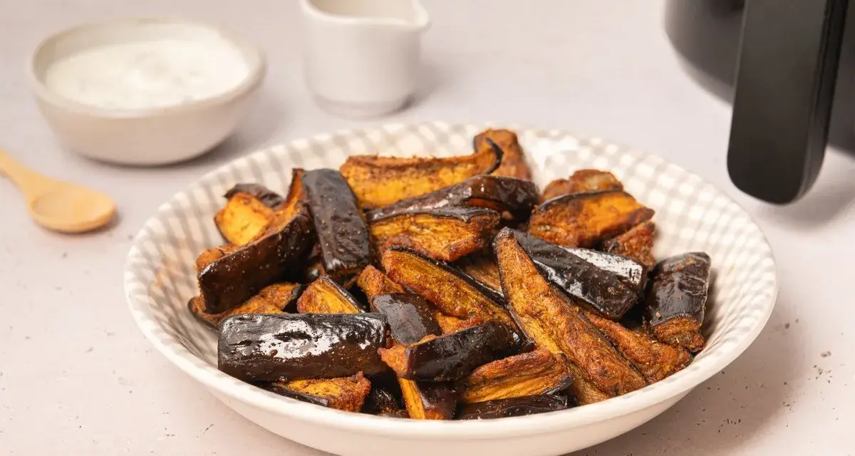 Berenjenas en freidora de aire, doradas y crujientes, listas para disfrutar con un dip cremoso.