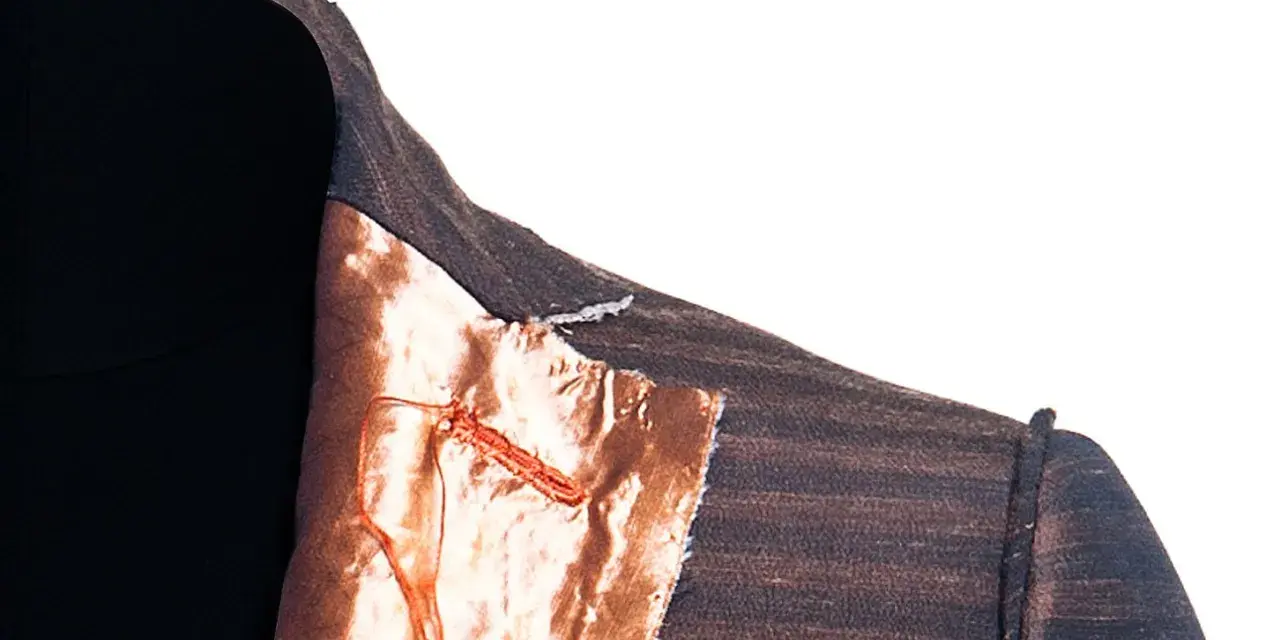 Dettaglio di una giacca destrutturata Armani con fodera color rame e cuciture a vista.
