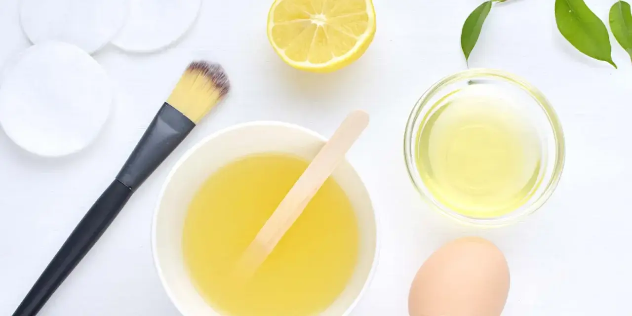 Ingredientes para una mascarilla casera para el pelo: limón, huevo, aceite y aplicador.