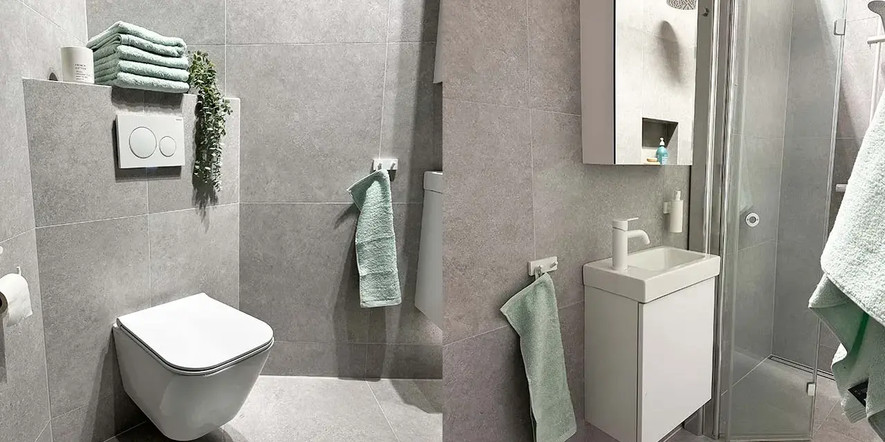Ett modernt, inrett litet badrum med grå kakelväggar, en vägghängd toalett, ett litet handfat och en duschkabin. Ljusa handdukar ger en mjuk kontrast.