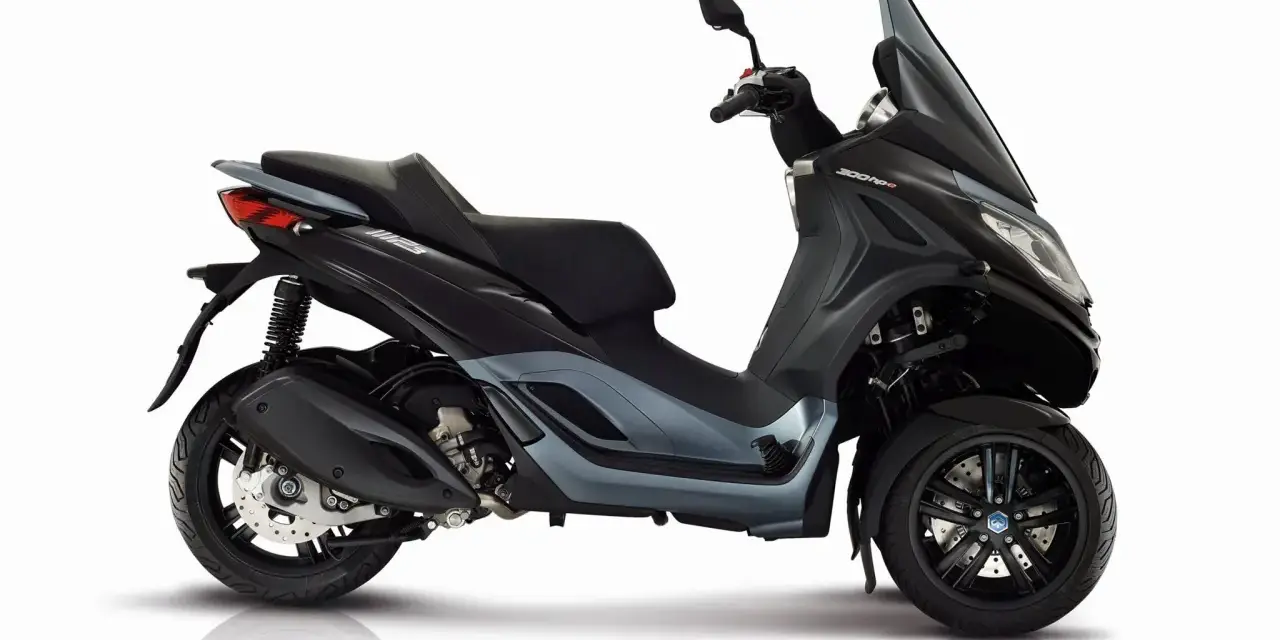 Trójkołowy skuter Piaggio MP3 300 HPE w kolorze grafitowym, z detalami podkreślającymi jego sportowy charakter. Idealny do miasta, z uwzględnieniem piaggio mp3 300 dane techniczne.