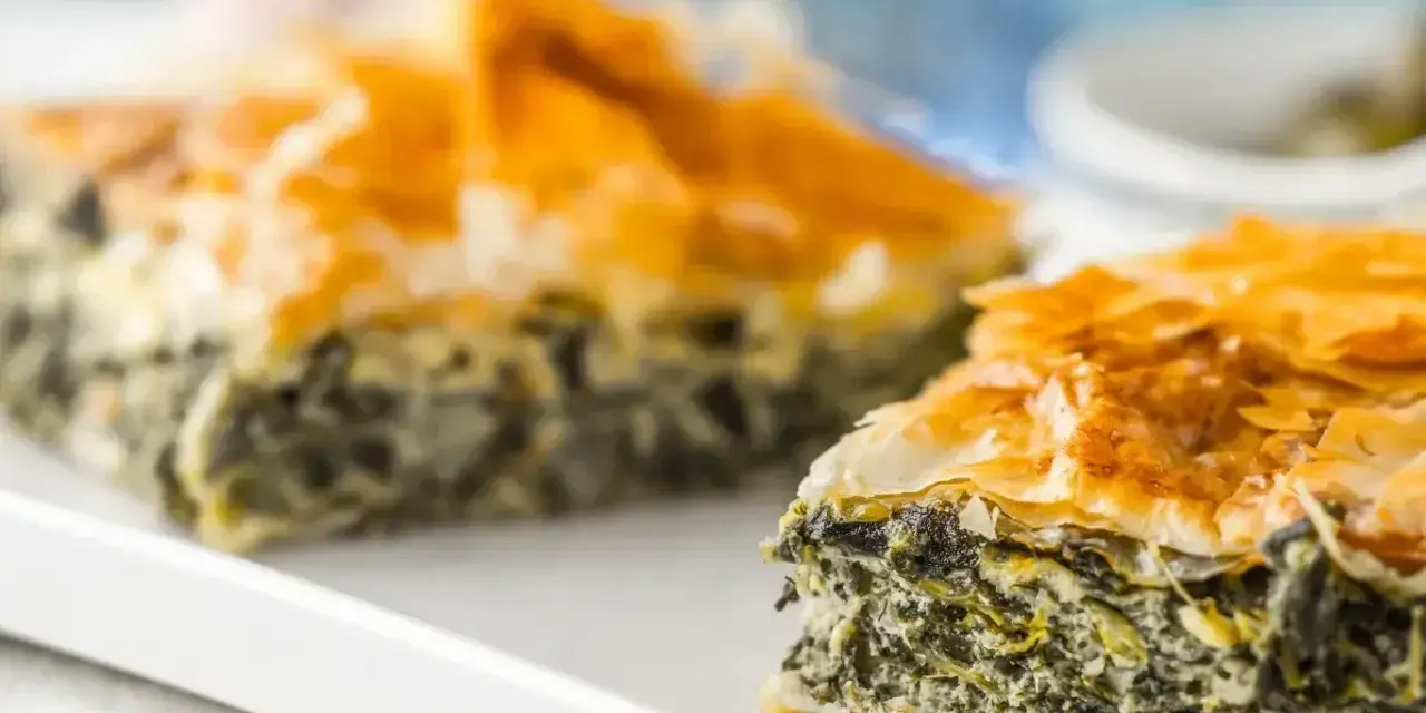 Chrupiąca spanakopita z warstwami ciasta filo i zielonym nadzieniem ze szpinaku i sera.
