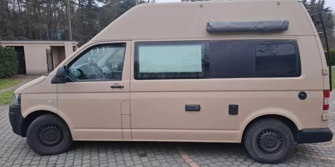 Kamper w piaskowym kolorze, pomalowany Raptor. Zastanawiasz się, ile kosztuje malowanie auta Raptor?