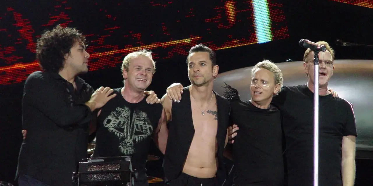 Les membres de Depeche Mode sur scène, souriants et complices, profitent de l'instant.