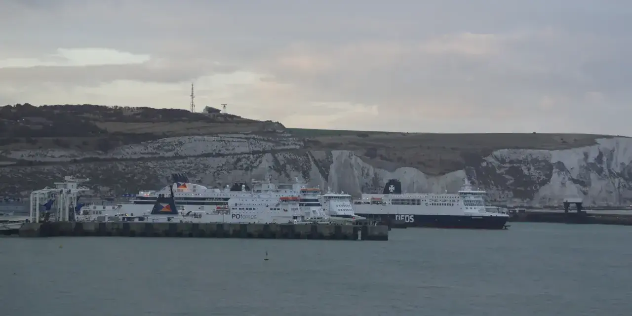 Kilka promów cumuje przy białych klifach. Jeden z nich, z napisem "DFDS", szykuje się do rejsu do Szkocji.