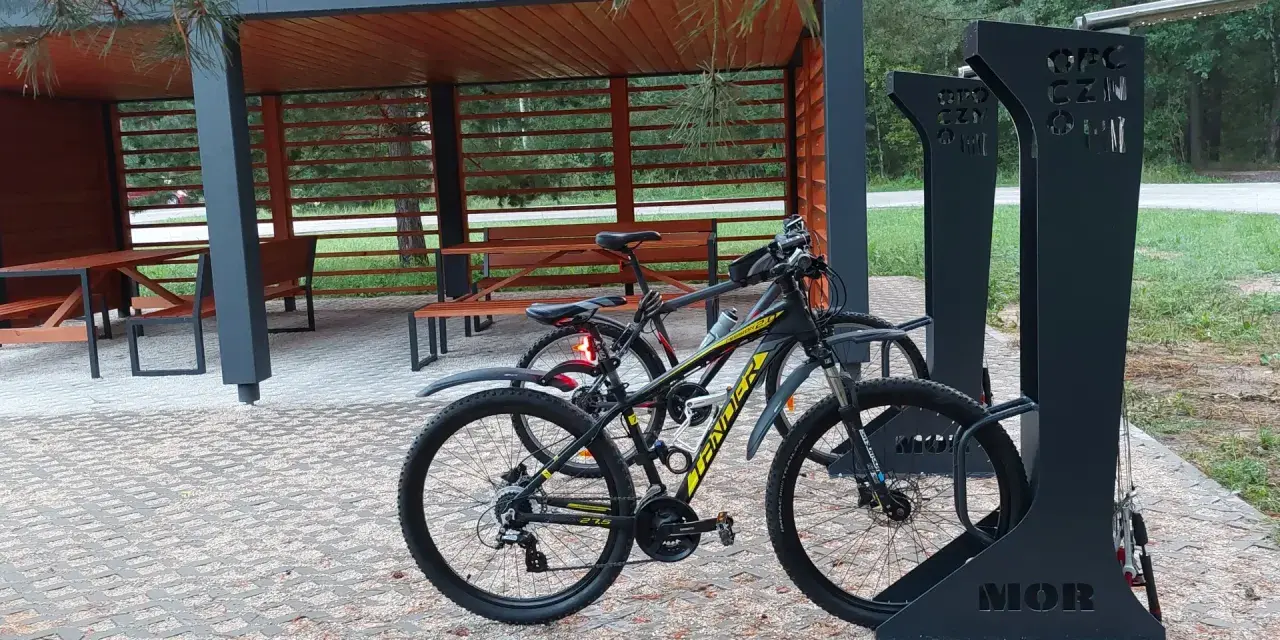 Miejsce obsługi rowerzystów z wiatą i stojakami. Dwa rowery czekają na dalszą podróż.
