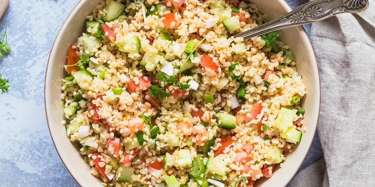 Frischer bulgur salat mit Tomaten, Gurken und Frühlingszwiebeln, garniert mit Petersilie.