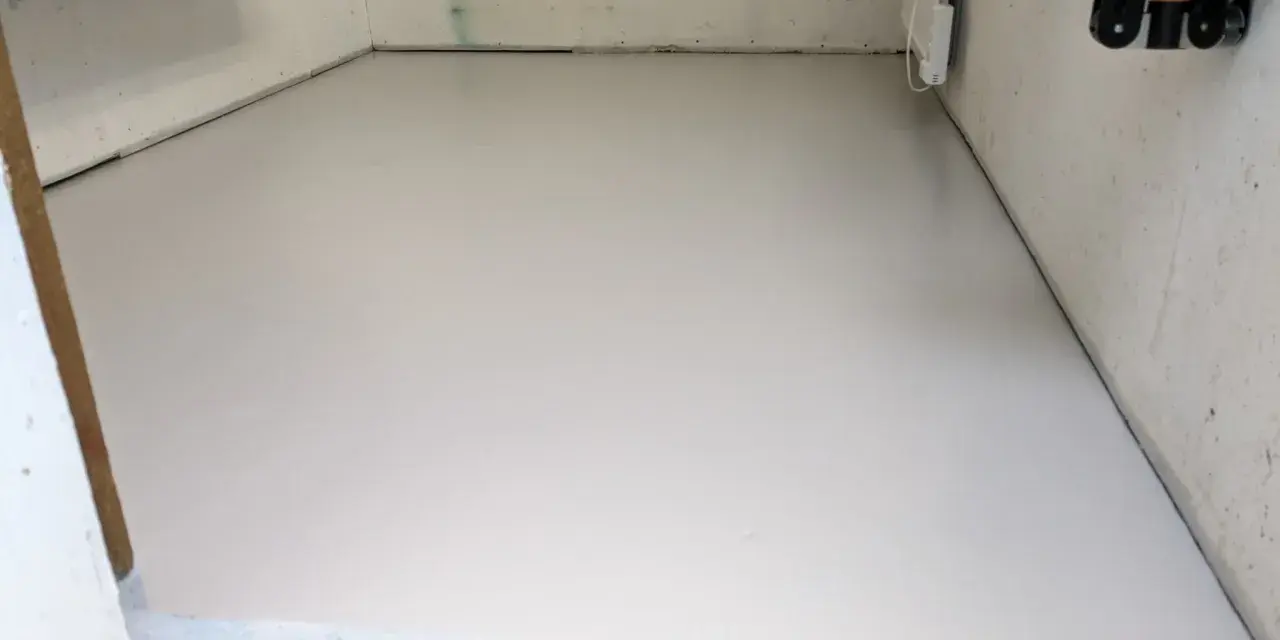 Nymålat betonggolv i ett förråd, redo för nya projekt.