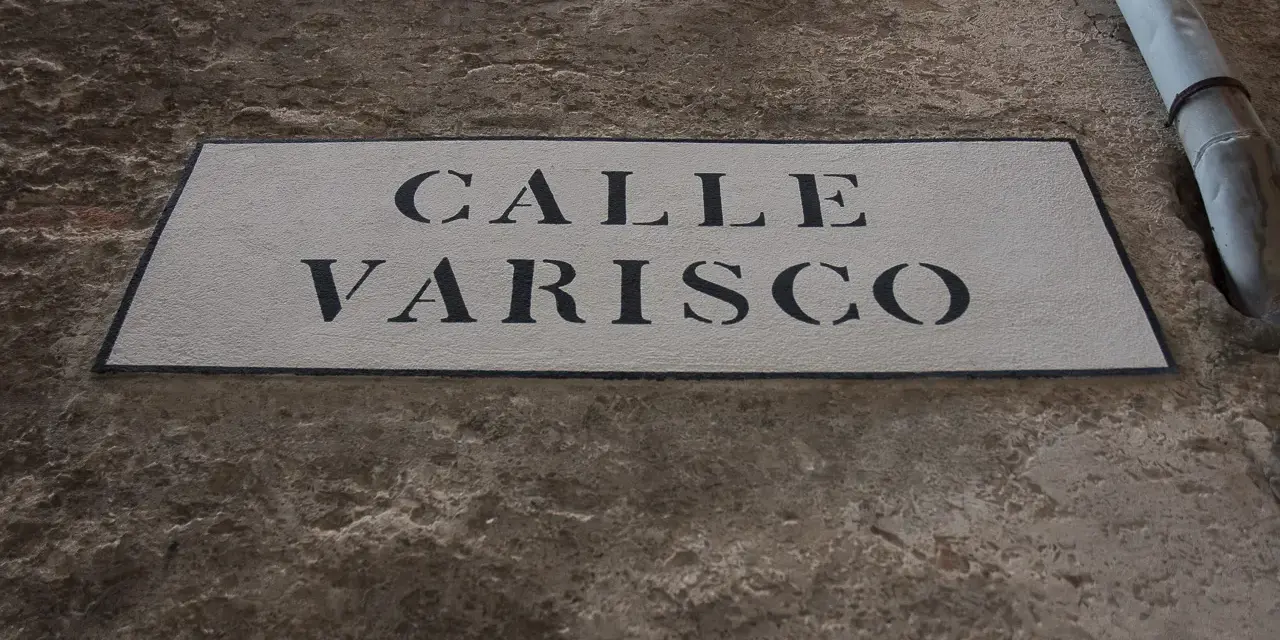 Targa in pietra con scritta "CALLE VARISCO" a Venezia, incastonata in un muro grezzo.