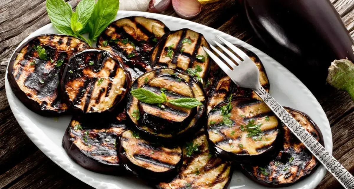 Melanzane grigliate condite con erbe fresche e olio d'oliva. Un contorno saporito e facile da preparare.