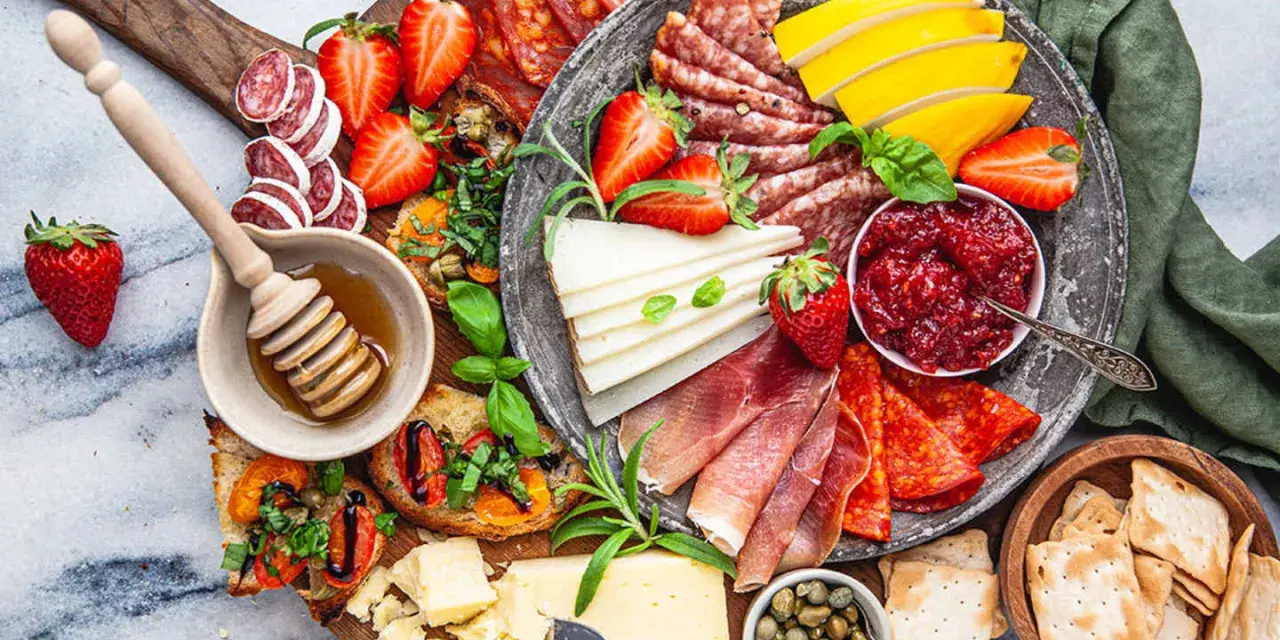 En härlig charkbricka med salami, prosciutto, ost, jordgubbar, marmelad och kex. Perfekt för mingel!