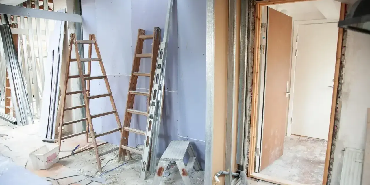 Remont mieszkania 60m2 w toku. Drabiny, poziomica i materiały budowlane wskazują na prace.