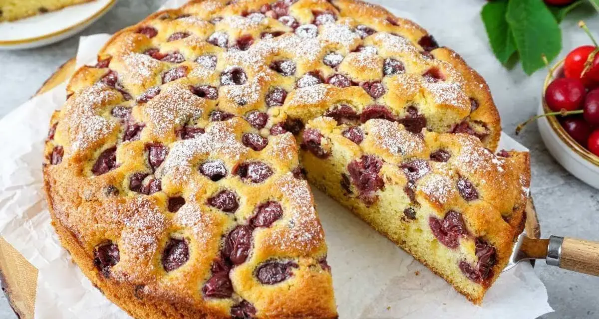Saftiger Kirschkuchen, perfekt für das Kirschkuchen Rezept. Mit Puderzucker bestäubt und voller Kirschen.