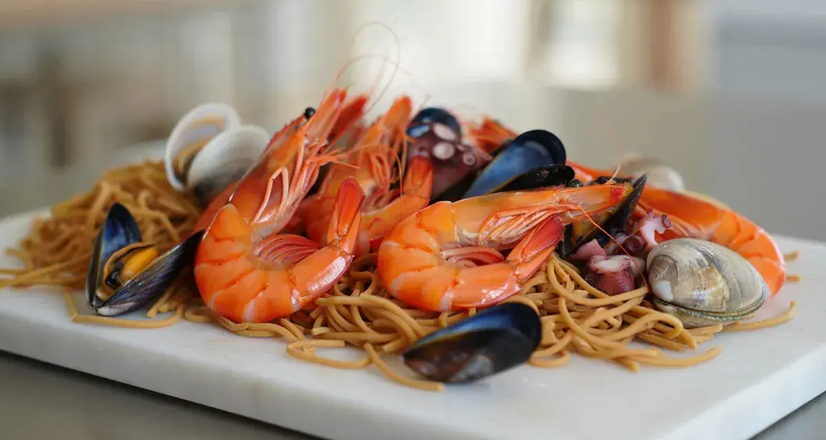 Fideuá de marisco con gambas, mejillones, almejas y pulpo sobre fideos finos.