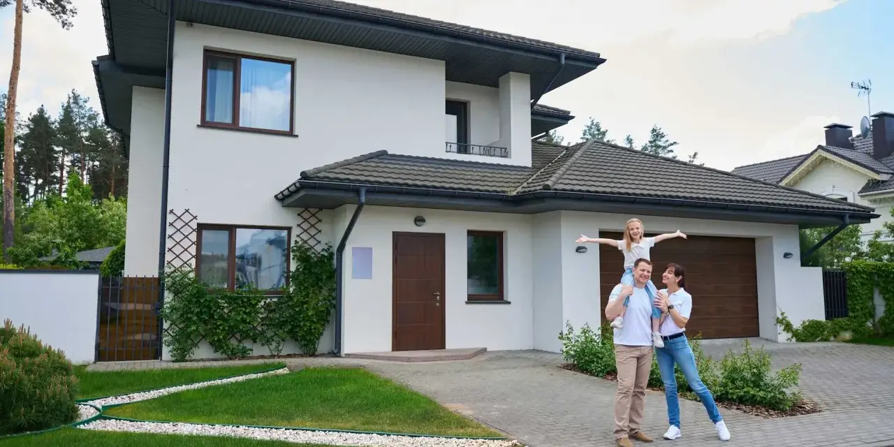Szczęśliwa rodzina przed nowoczesnym domem. Realizacja marzeń o własnym M, gdzie koszt budowy domu 100m2 jest w zasięgu ręki.