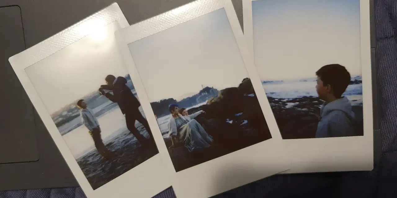 Trzy zdjęcia jak z Instax: chłopiec na plaży, para na skałach i chłopiec patrzący na morze.
