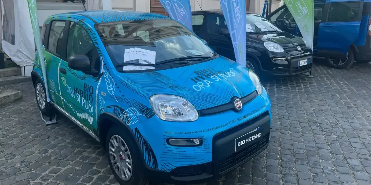 Una Fiat Panda blu con grafica "BIO HYBRID ORA SI PUÒ" e "BIO METANO". Un'auto ecologica che passa da metano a benzina da sola.
