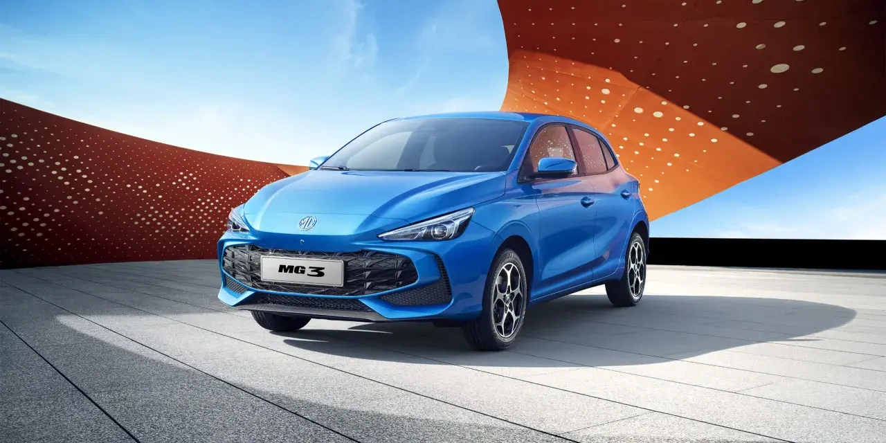 Niebieski MG3 Hybrid stoi na tle nowoczesnej architektury i błękitnego nieba.