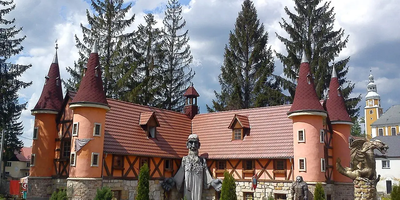 Zamek śląskich legend z wieżyczkami i kamiennymi rzeźbami.