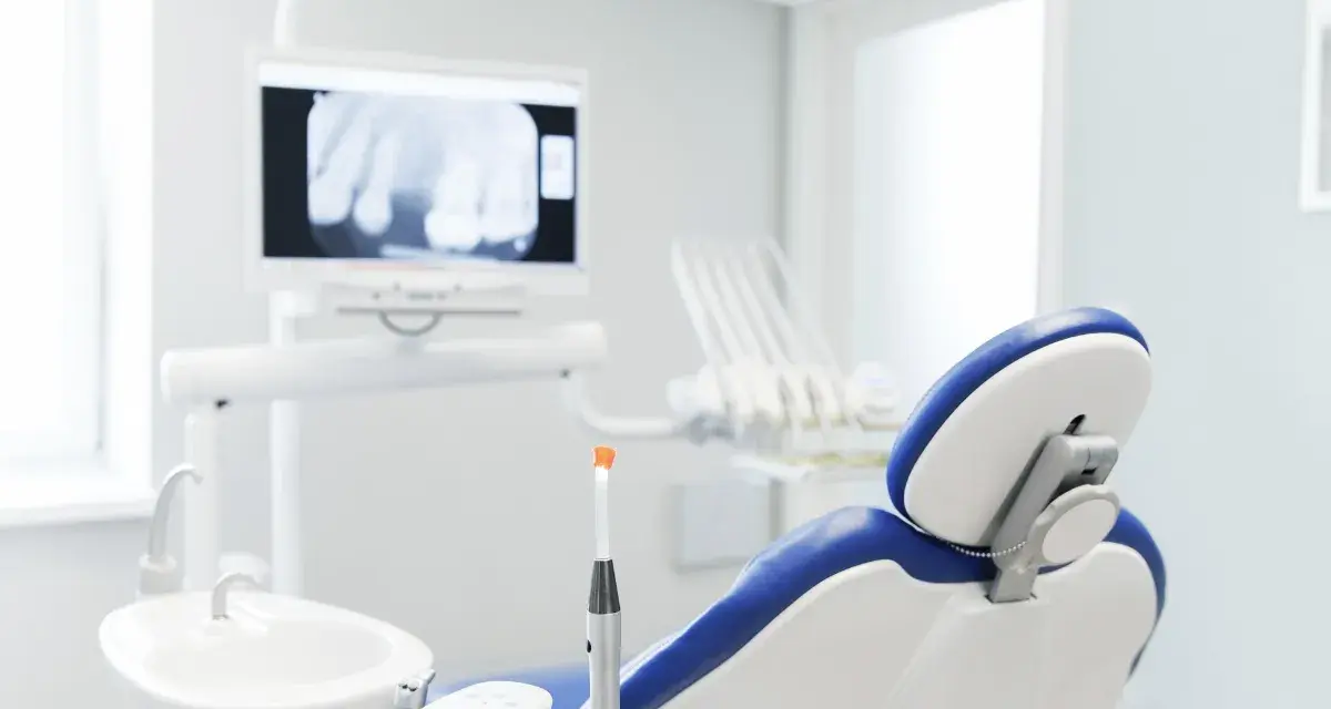 Gabinet dentystyczny z fotelem i aparaturą. Nawet gdy masz przeziębienie, dentysta czeka, by zadbać o Twój uśmiech.
