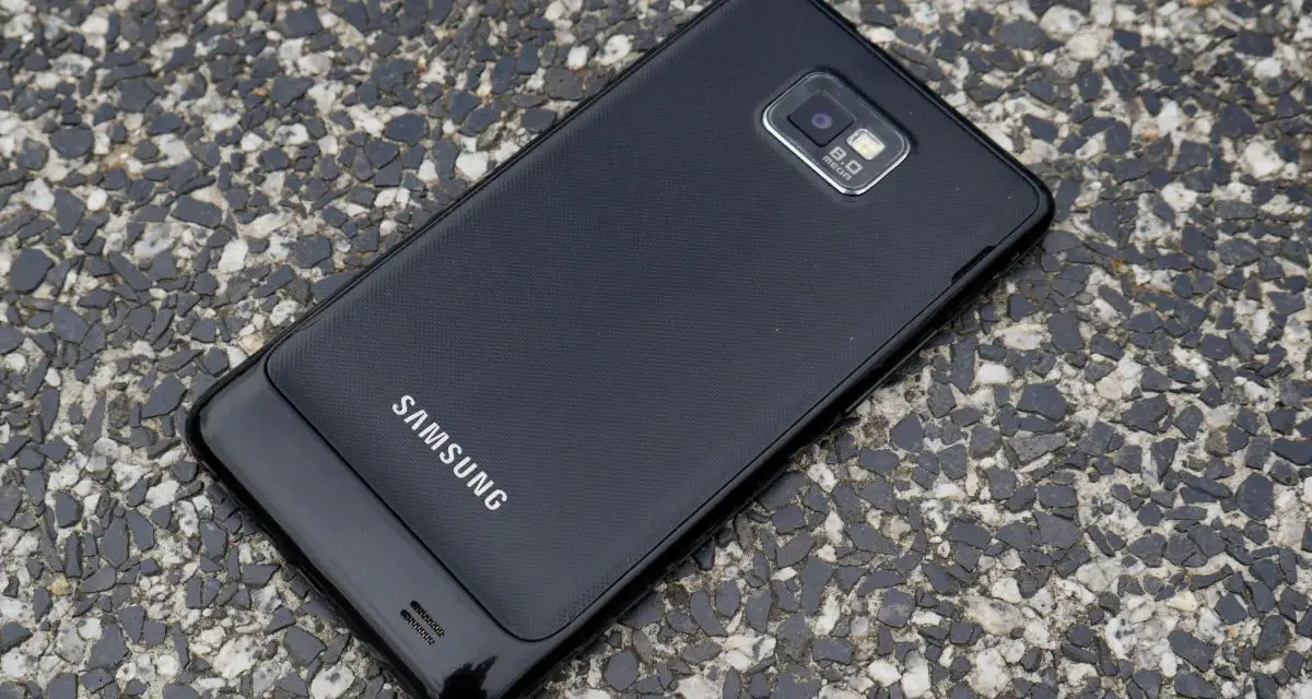 Czarny Samsung Galaxy S2 leży na kamienistej nawierzchni.