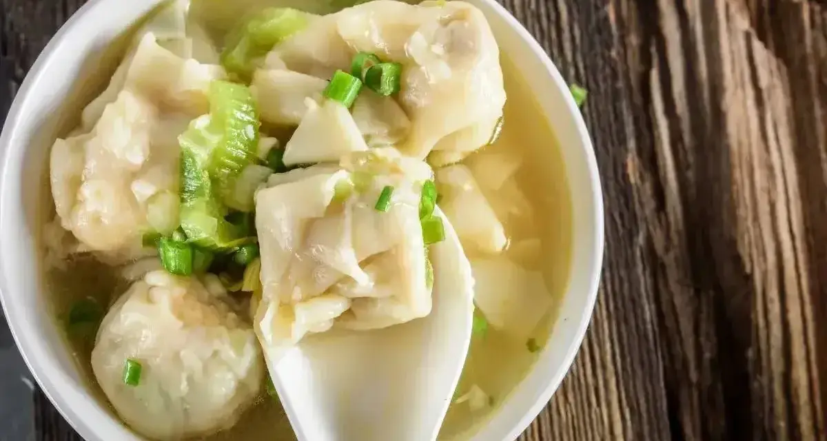 Miseczka aromatycznej zupy z wontonami, gdzie delikatne ciasto do wontonów otula pyszne nadzienie. Posypana szczypiorkiem.