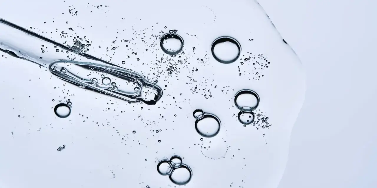 Kropla serum z pipetką, pełna pęcherzyków powietrza. Czy peptydy można łączyć z witaminą C? To pytanie nurtuje wiele osób dbających o cerę.