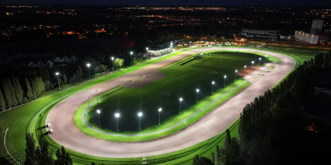 Vue aérienne d'un hippodrome illuminé la nuit, rappelant le nombre d'hippodrome en France.