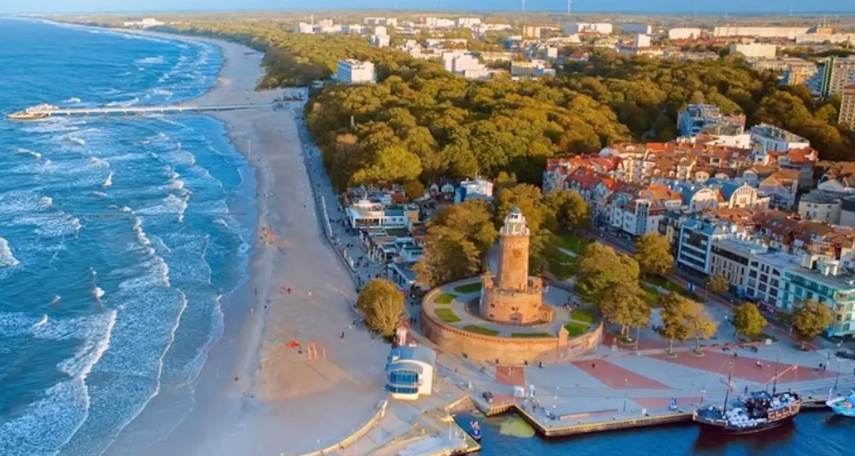 Idealne miejsce, gdzie nad morze. Widok na plażę, molo, latarnię i nadmorskie miasteczko.