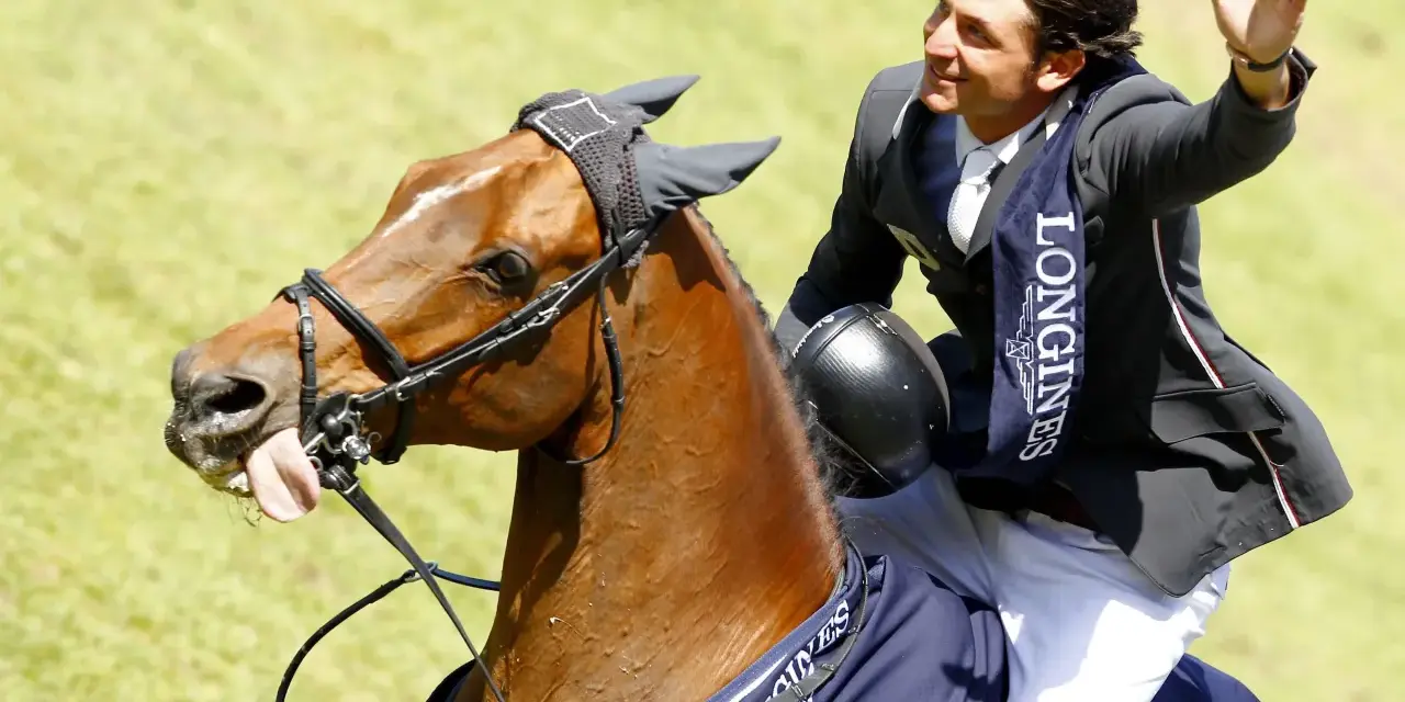 Un cavalier, Nino des Buissonnets, salue la foule depuis son cheval après une compétition.