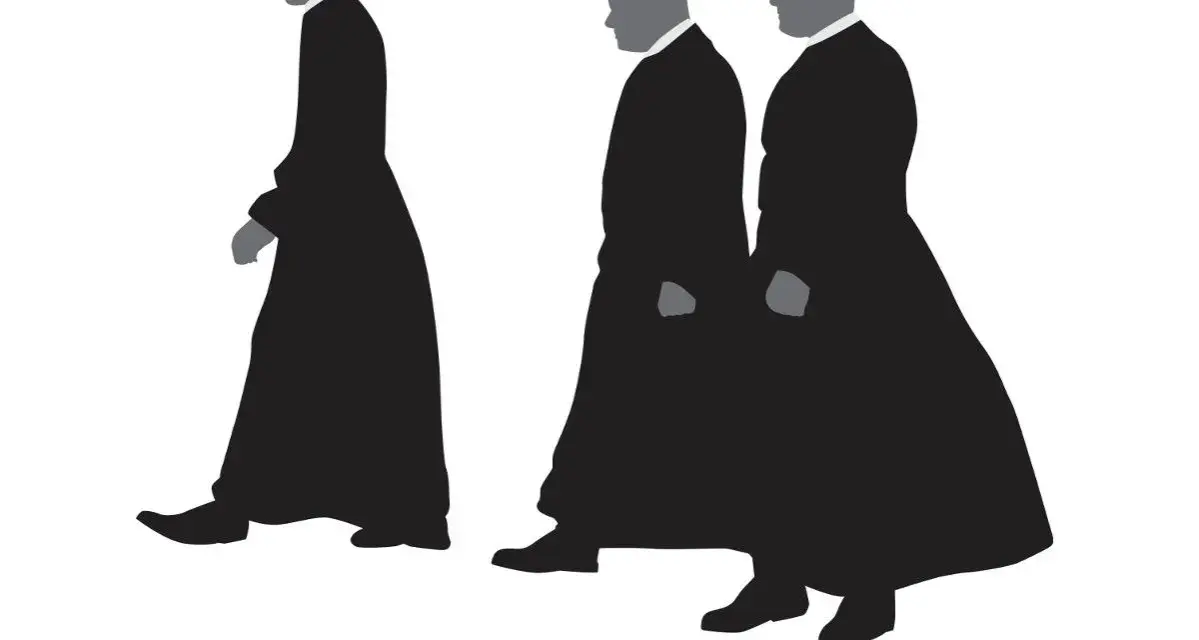 Trzech mężczyzn w czarnych, długich szatach, przypominających stroje duchownych. Kim jest kanonik? To godność kościelna, często związana z katedrą.