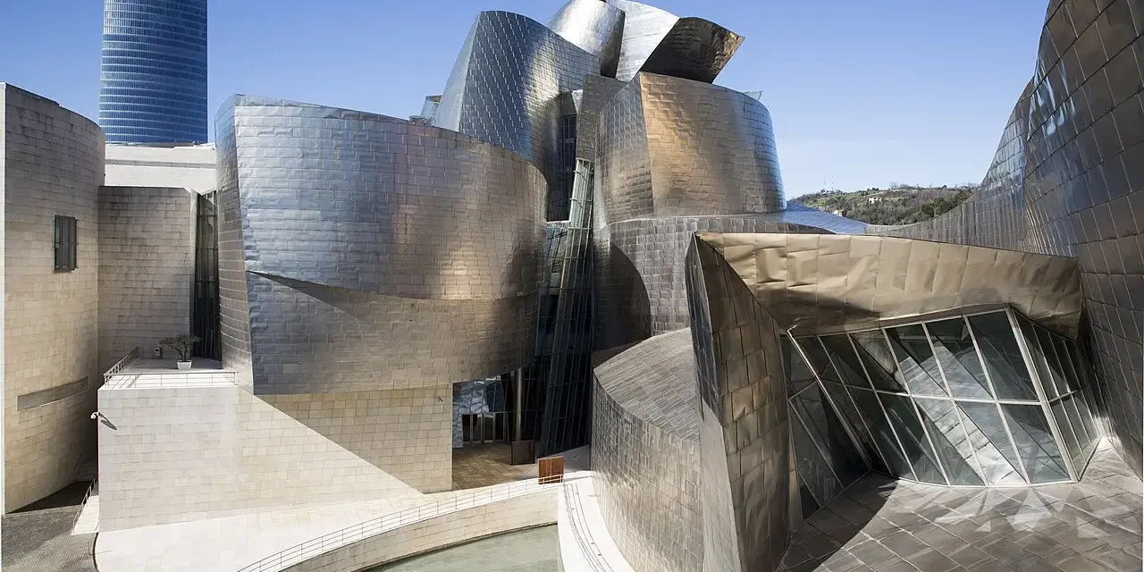 Spektakularny efekt Bilbao: falujące, metaliczne formy Muzeum Guggenheima w Bilbao, odbijające niebo i otoczenie.