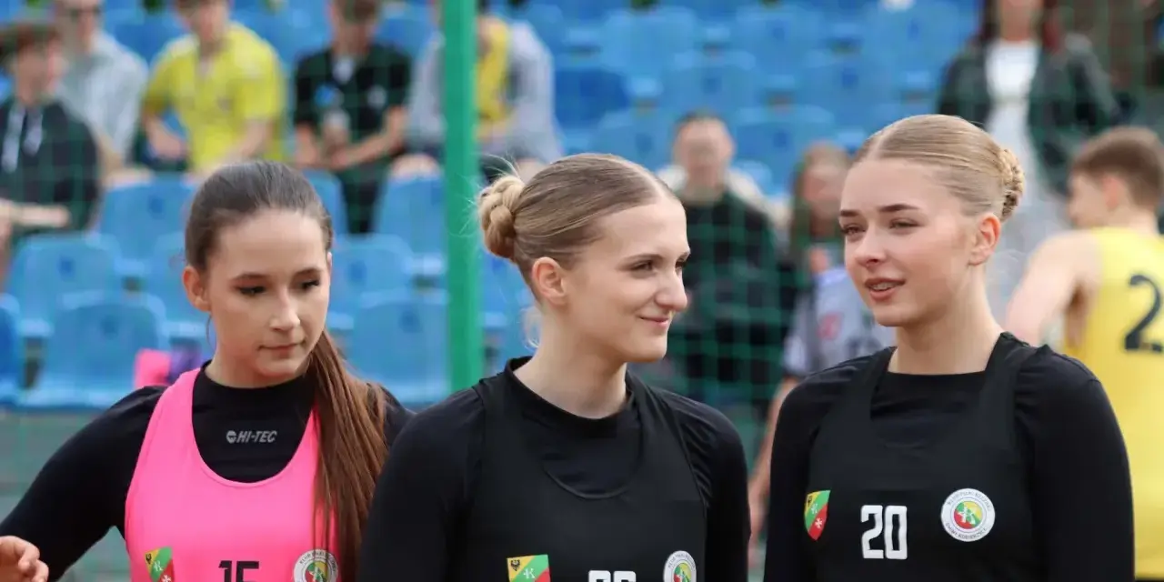Trzy zawodniczki KPR Kobierzyce przed meczem. Dziewczyny w sportowych strojach, z numerami na koszulkach, gotowe do gry.