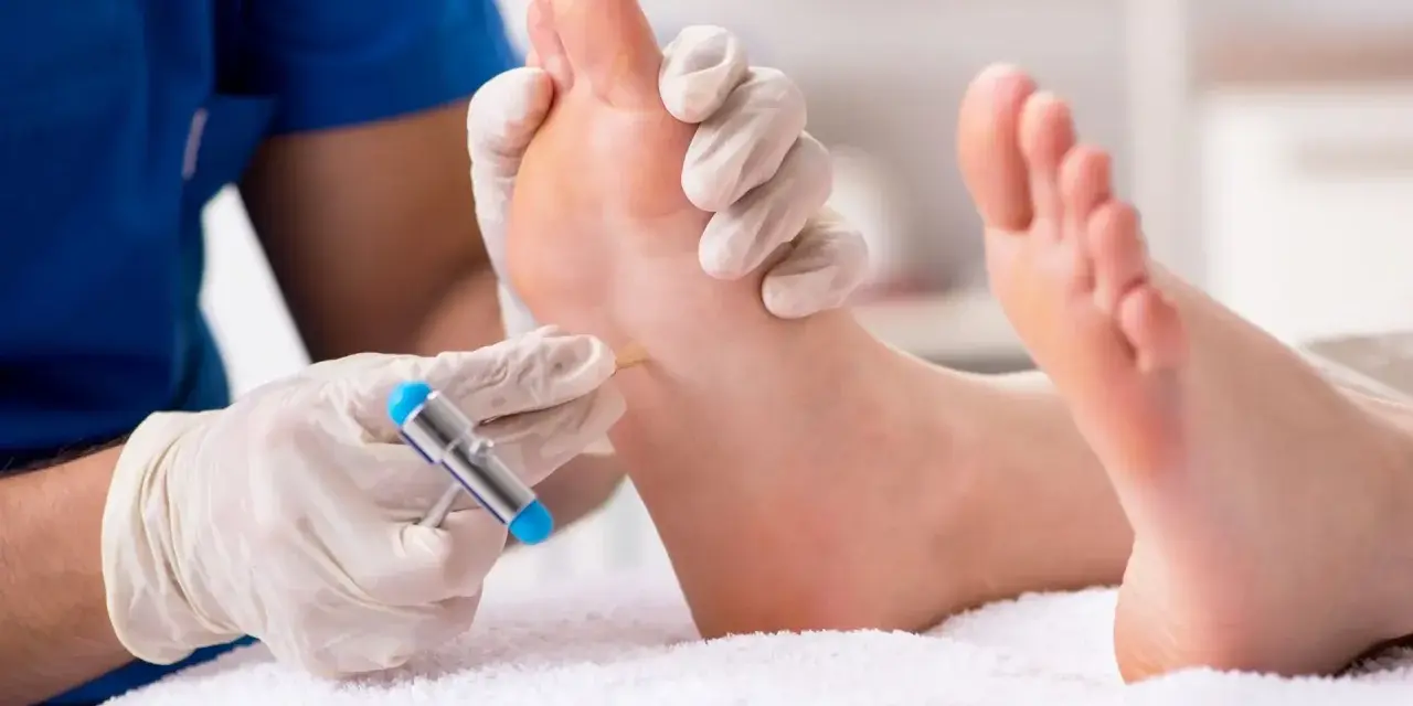 Badanie neurologiczne stopy, sprawdzanie odruchu Babińskiego za pomocą młoteczka.