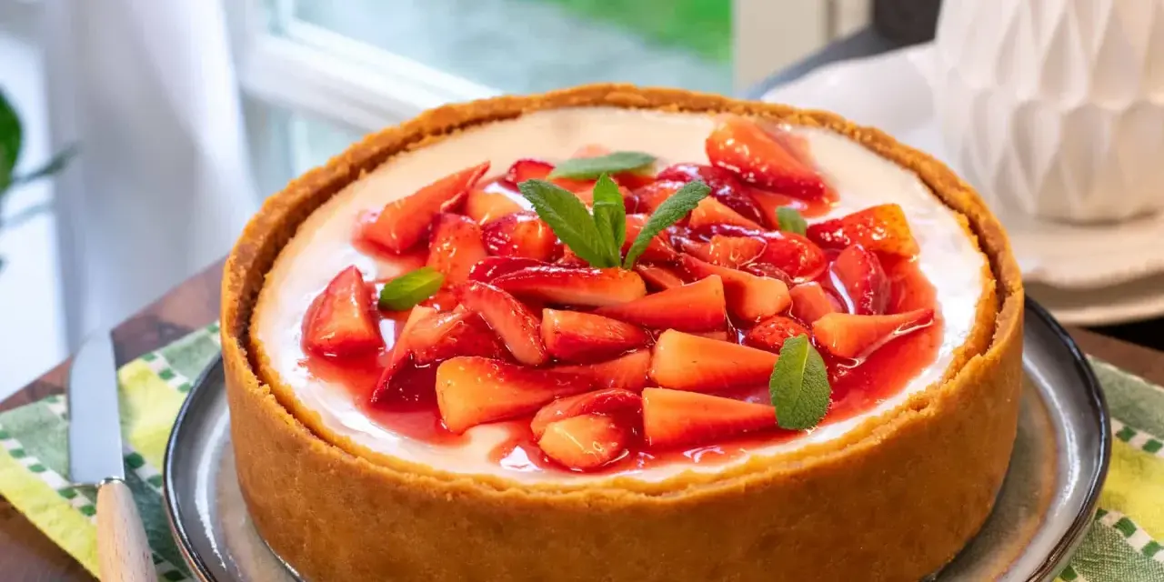 Cheesecake con mascarpone e fragole fresche, guarnita con menta. Un dolce invitante, perfetto per ogni occasione.