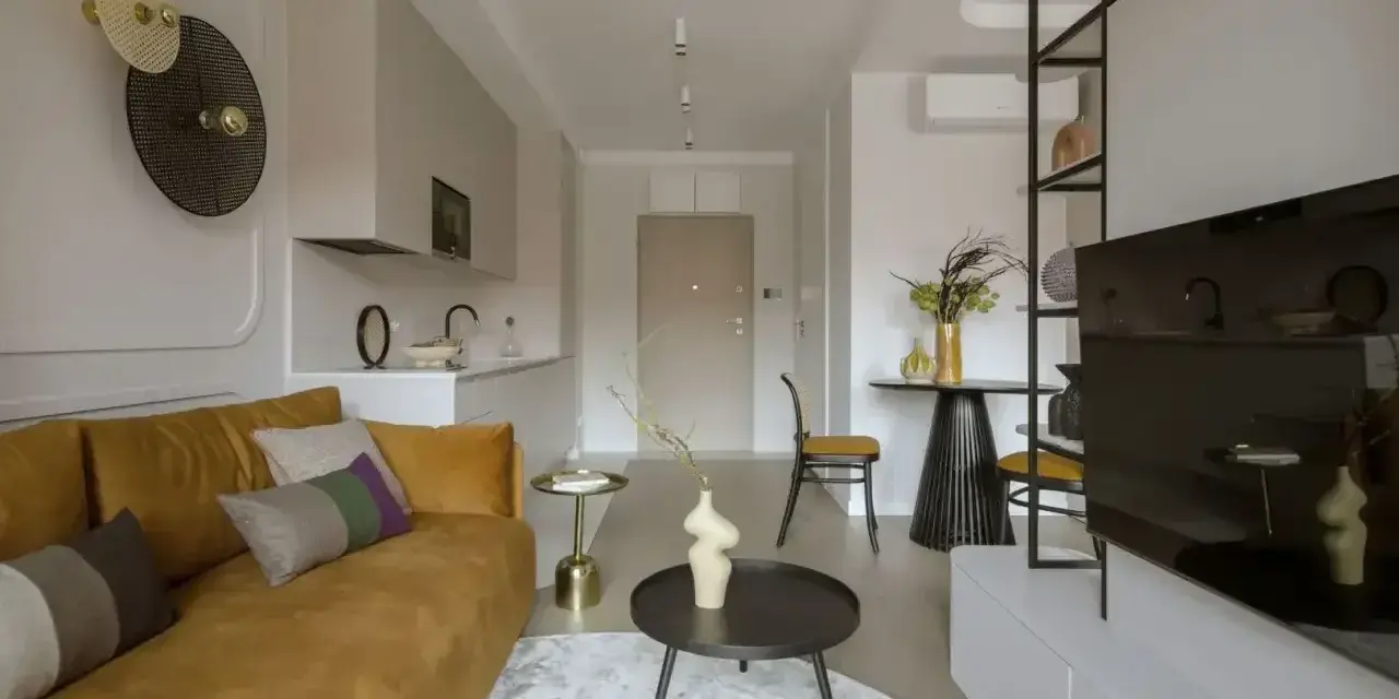 Nowoczesny salon z kanapą w kolorze musztardowym, tworzącą ciepłą paletę kolorów ziemi.